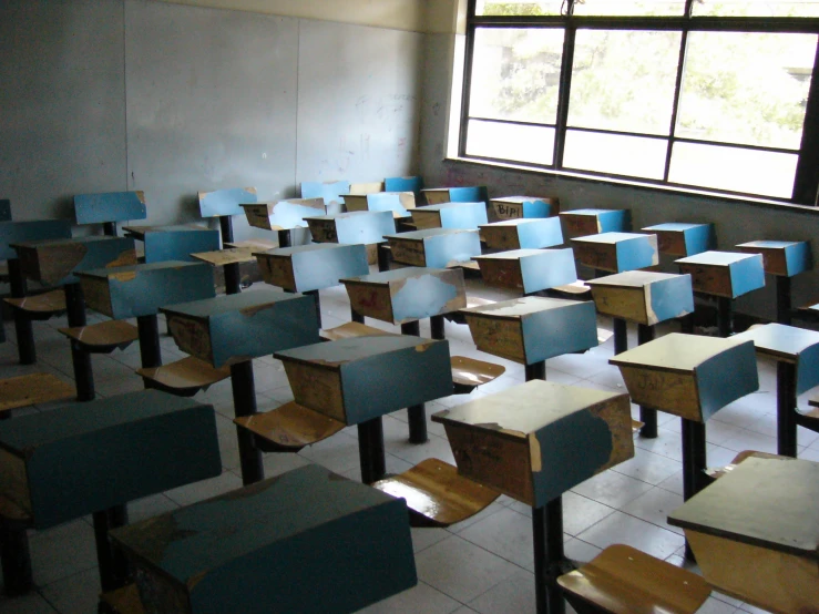 a classroom with many wooden chairs and a large window