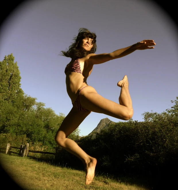 a woman jumping in the air with her arms outstretched