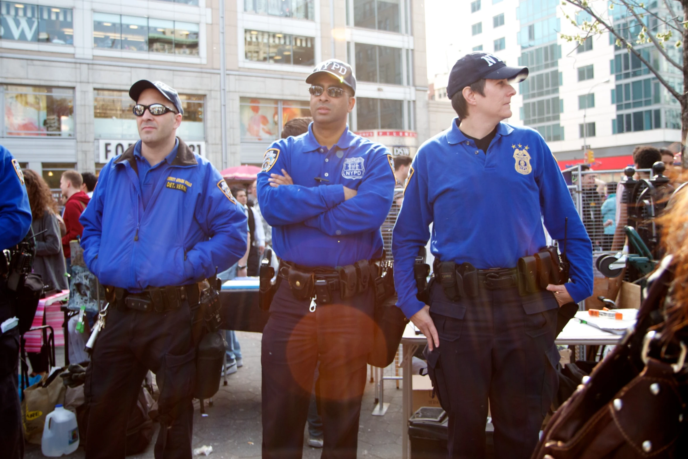 three uniformed police men in front of a group of people