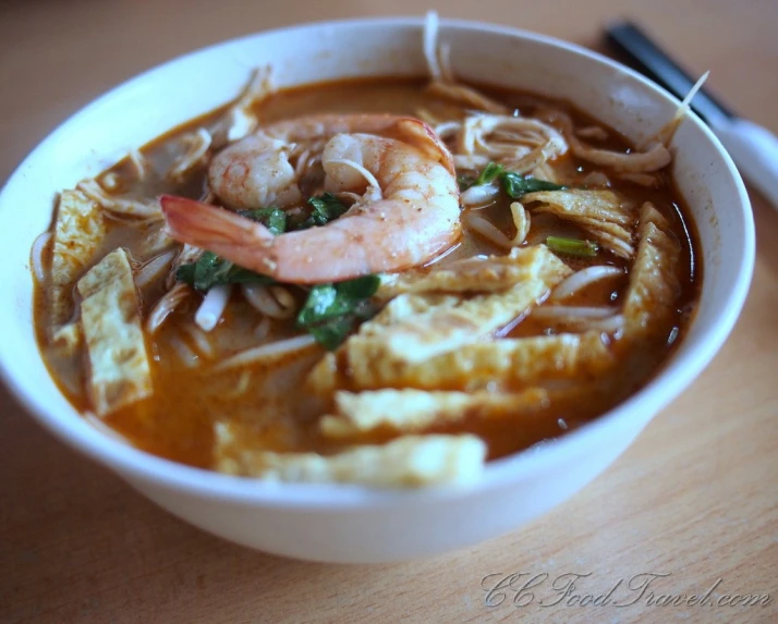 a bowl of shrimp and vegetable soup on the table