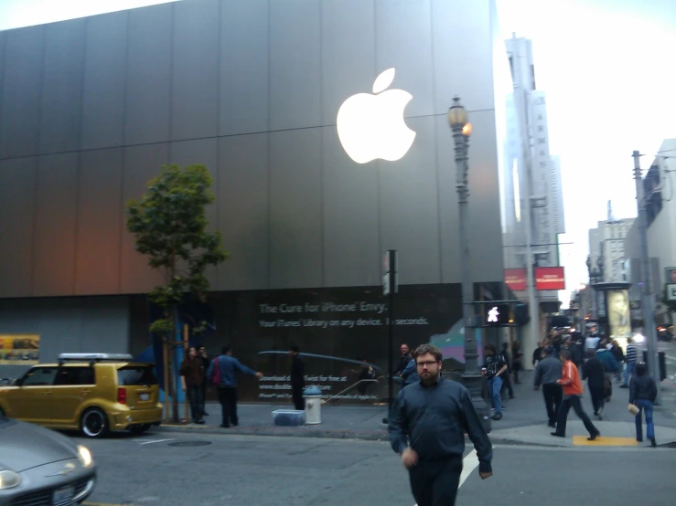 man walking down sidewalk in front of apple store