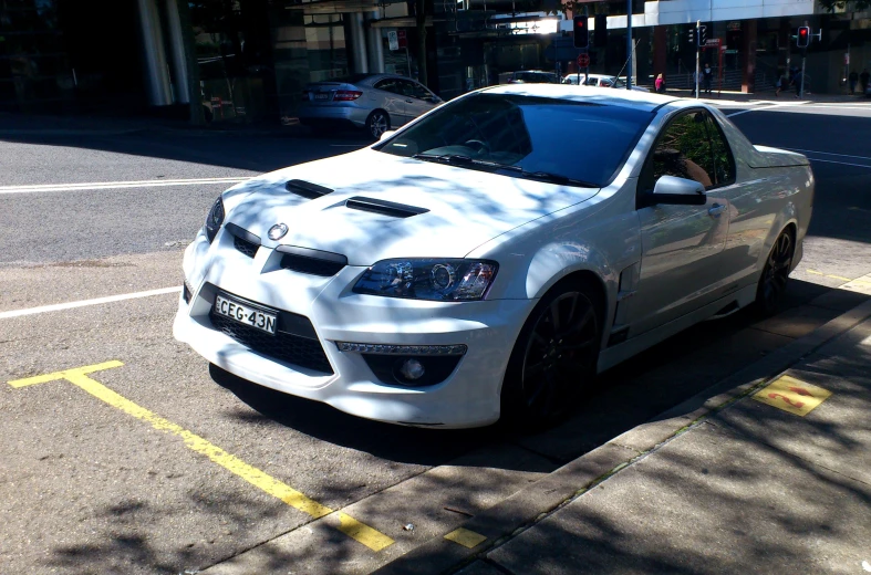 a white compact car parked on a street side