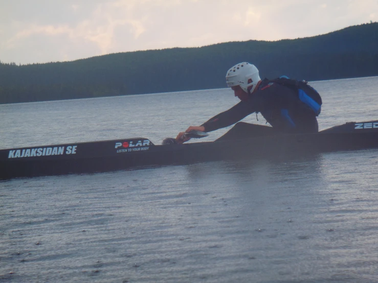 a man in helmet on top of a canoe