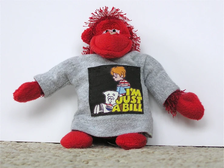 a stuffed toy monkey with a red mohawk