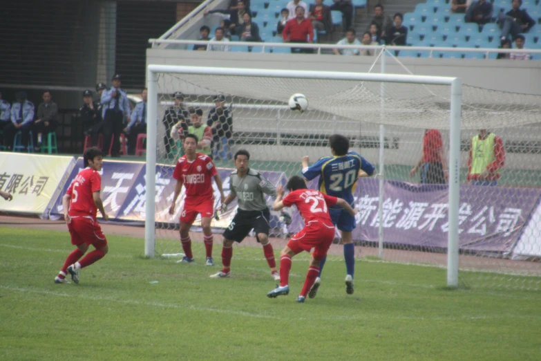 group of men in uniform playing soccer in front of a crowd