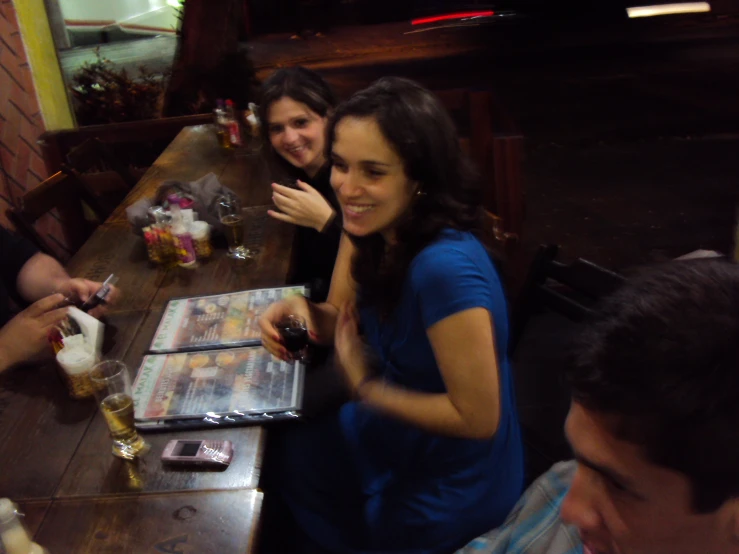 a group of people are having drinks at a long wooden table