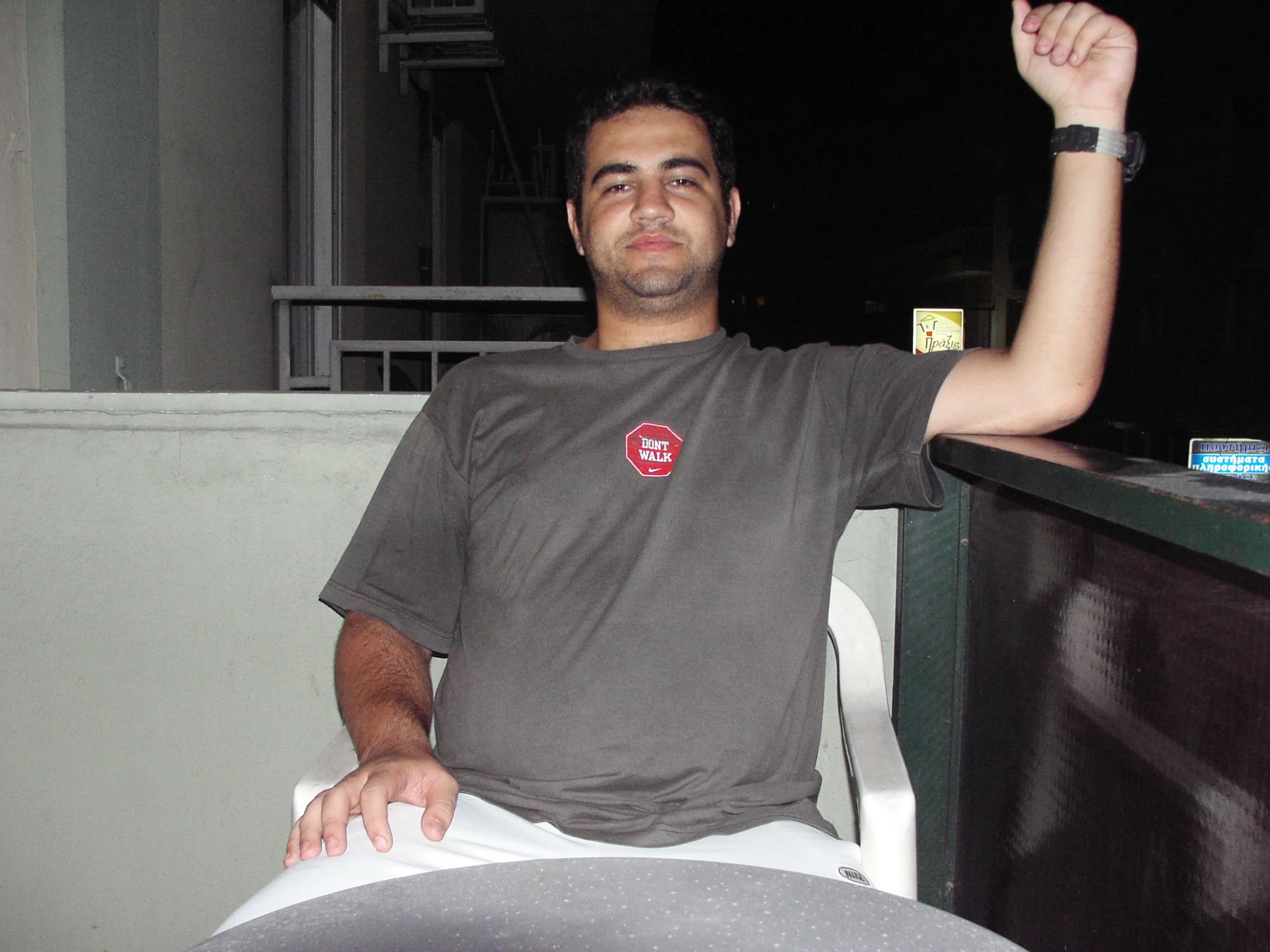 a man poses in his patio chair with his arm in the air