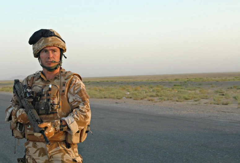 a man dressed in uniform with an automatic rifle