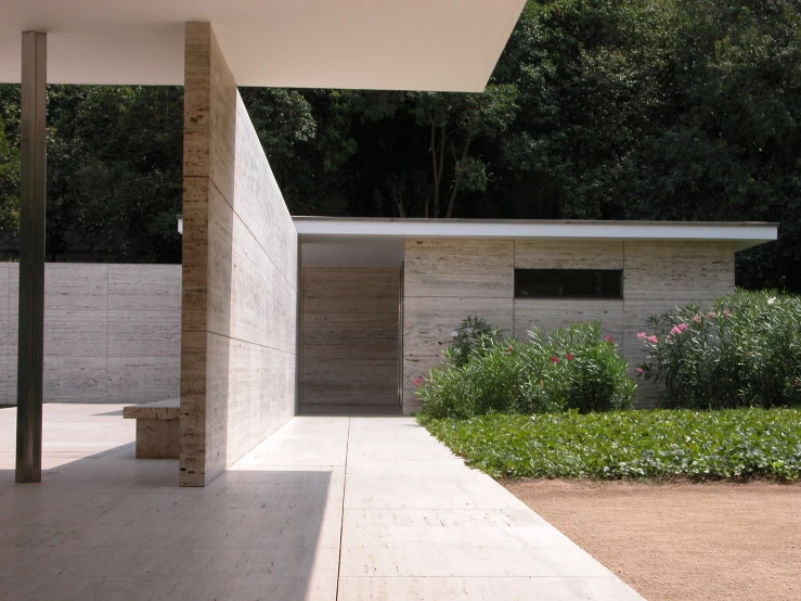 a stone walkway leading to a building surrounded by flowers