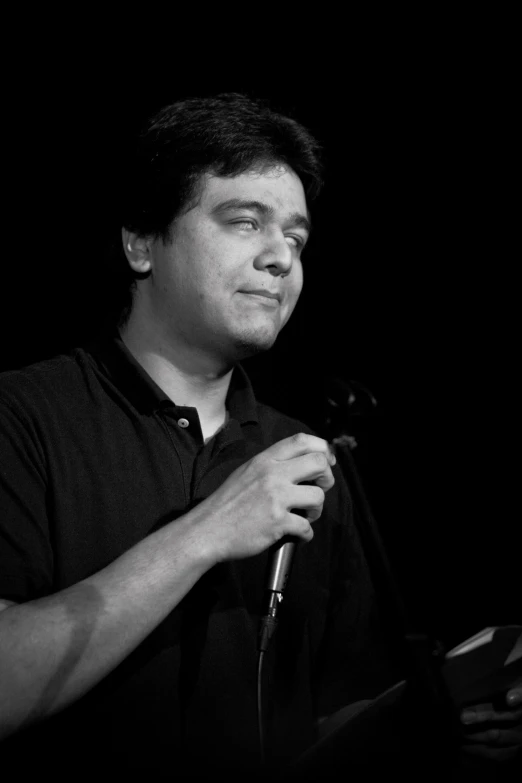 a black and white po of a man standing next to a microphone