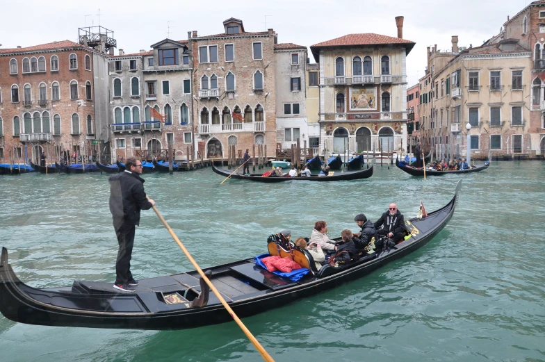 a man in a black suit is on the boat in venice