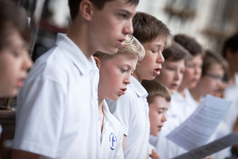 some children singing with sheets of paper in front of them