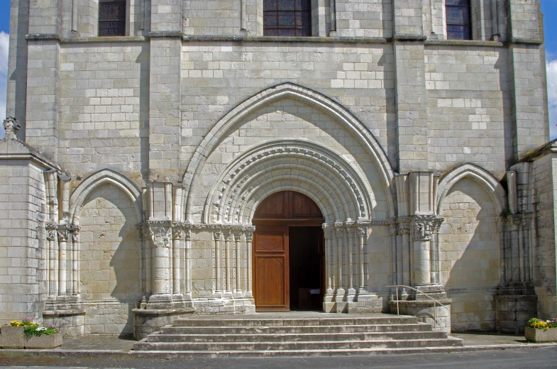 large arched doorway with set steps in old stone church