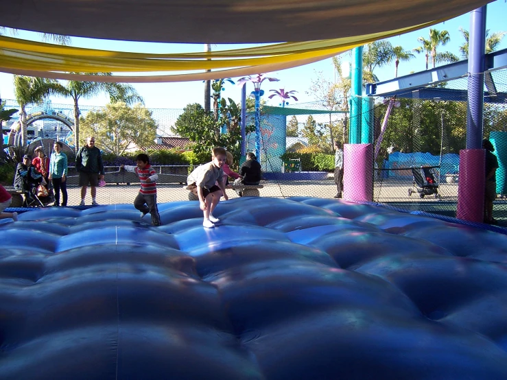 people walking around on an obstacle that appears to be a huge ball pit