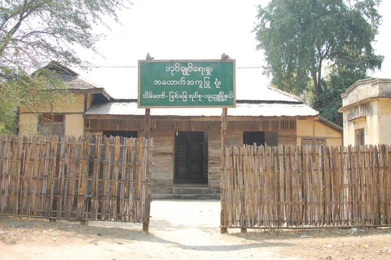 an asian village building with a green sign