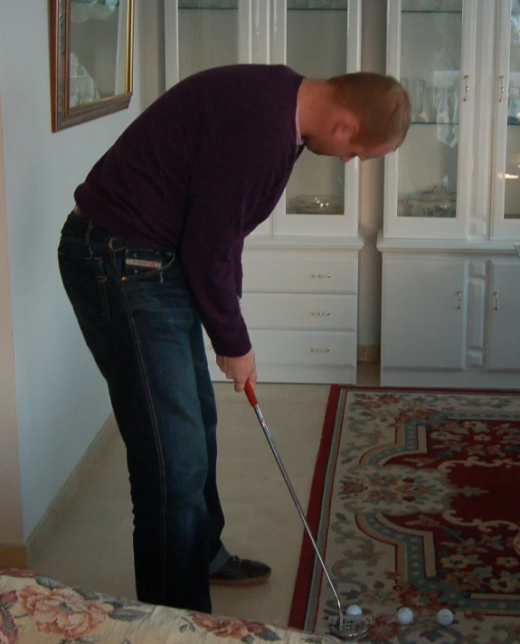 a man playing a golf game in the living room