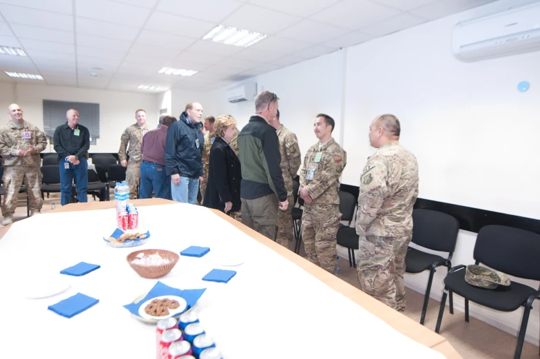 military men looking at various snacks at a function