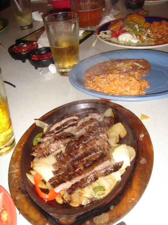 a plate filled with meat and vegetables, next to another plate with food