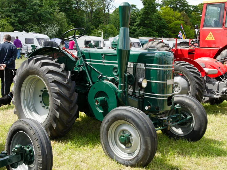 an old tractor parked next to another red tractor