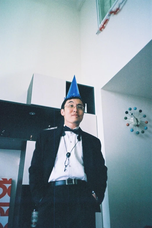 a man wearing a party hat next to a mirror