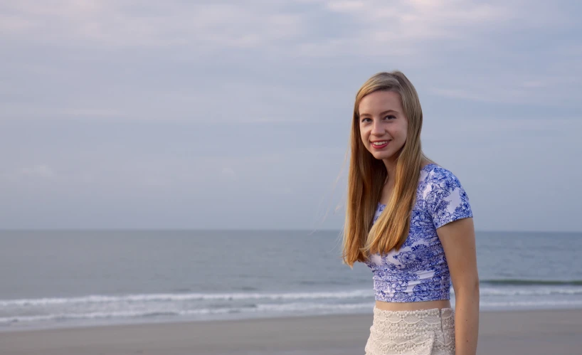 a woman with long hair is standing on the beach