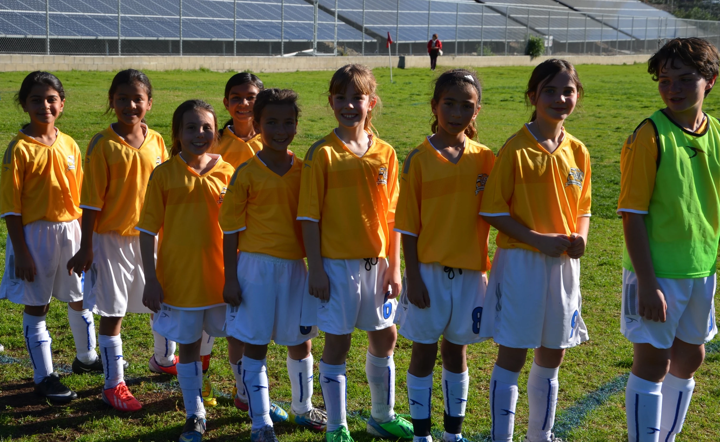 a group of little girls standing on top of a field