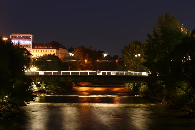 a view of a train passing over a bridge in the night