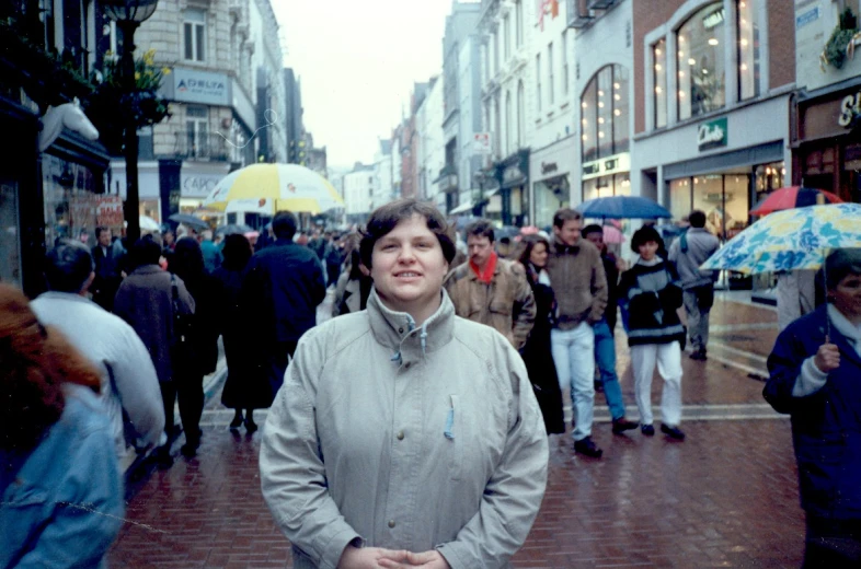 a boy standing in front of a bunch of people with umbrellas