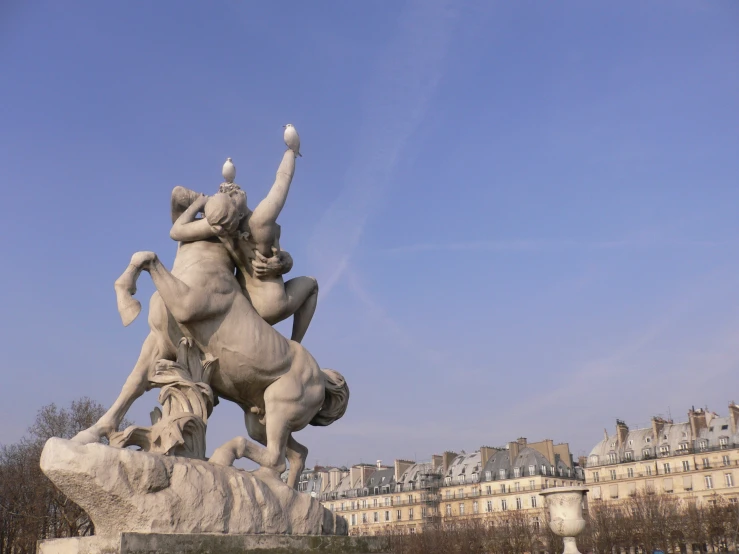 a statue with a statue of a man on horseback in front of the city