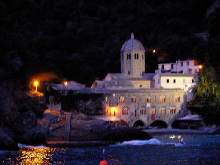 a group of white buildings sitting on top of a hill next to the ocean