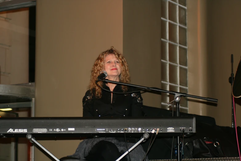 a woman with a microphone and a keyboard on the stage