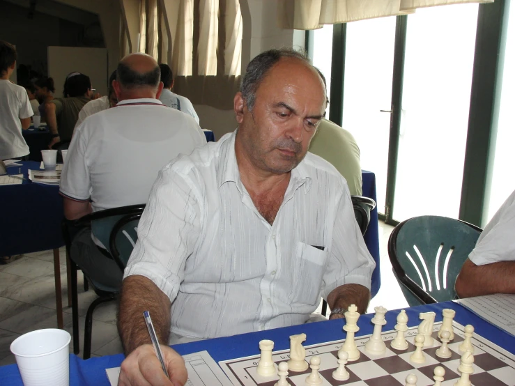 a man at a table in front of a chess game
