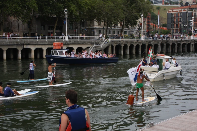 a crowd of people are on paddle boards in the water