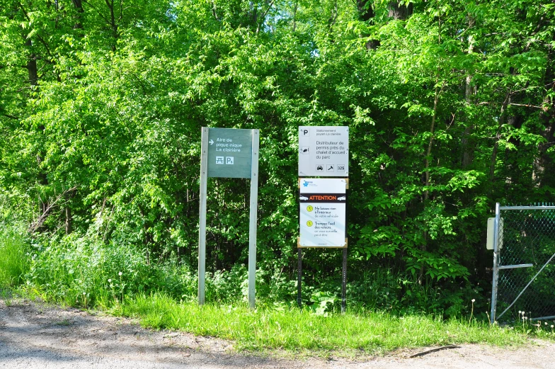 a sign on a road next to some green trees