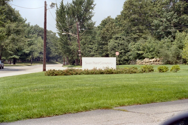 the street sign is in the foreground and on the far left side of a sidewalk