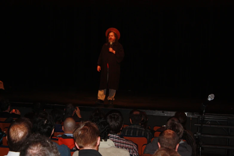 a man on stage, performing an upcoming event