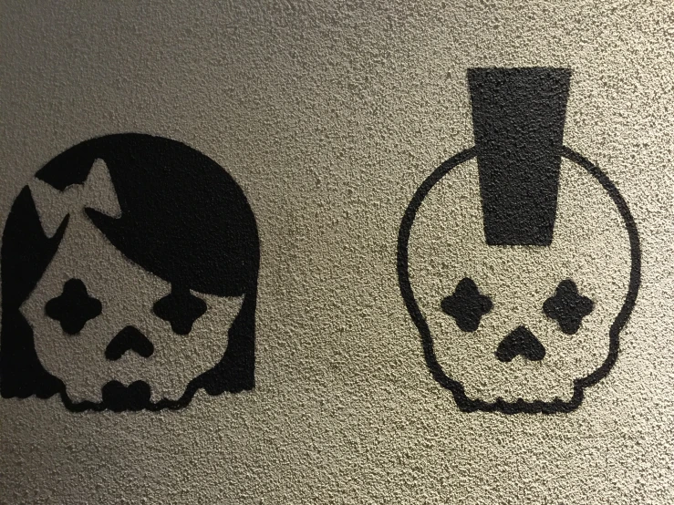 the two black skull paintings are next to each other