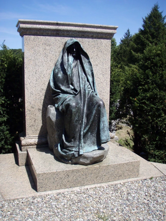 a statue with a blanket covering it in front of trees