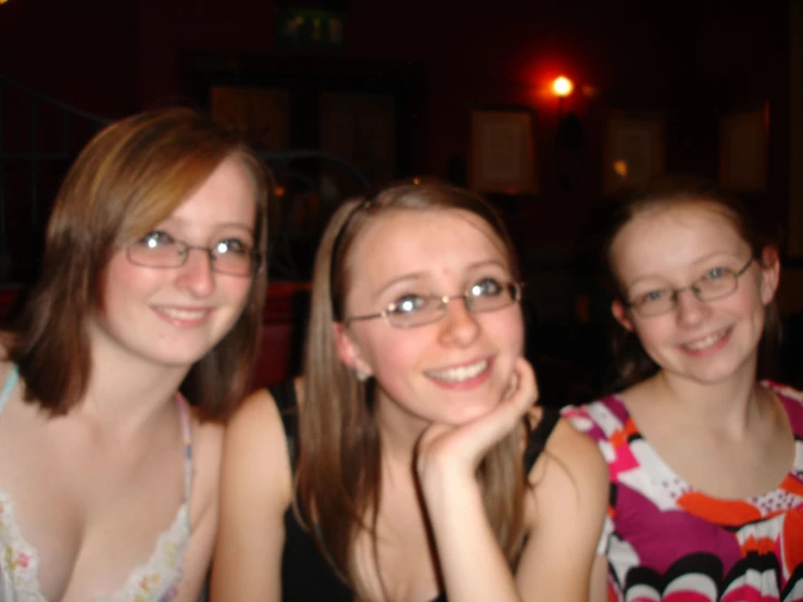 three girls sitting together, one with her chin on her head