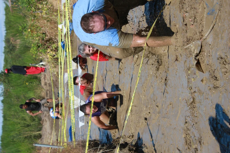 people are playing in mud near a river
