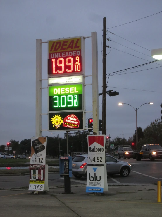 a gas station with various prices and different cars