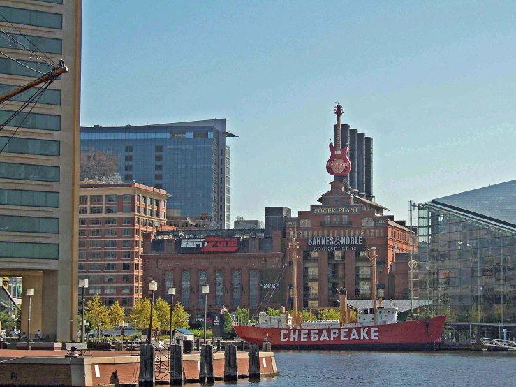 a city skyline with buildings and a red and white boat