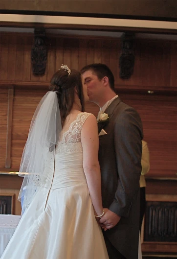 the newly married couple is kissing on their wedding day