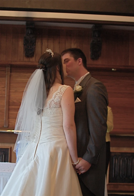 the newly married couple is kissing on their wedding day