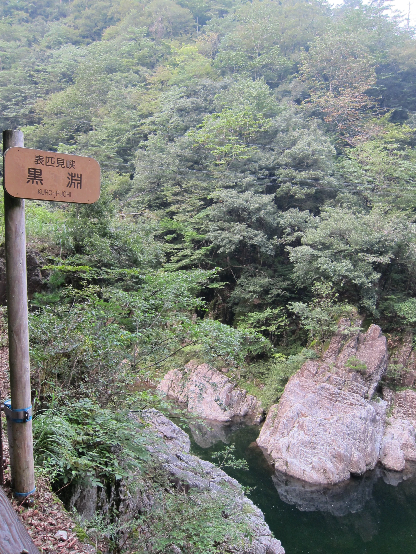 a sign on a trail next to water