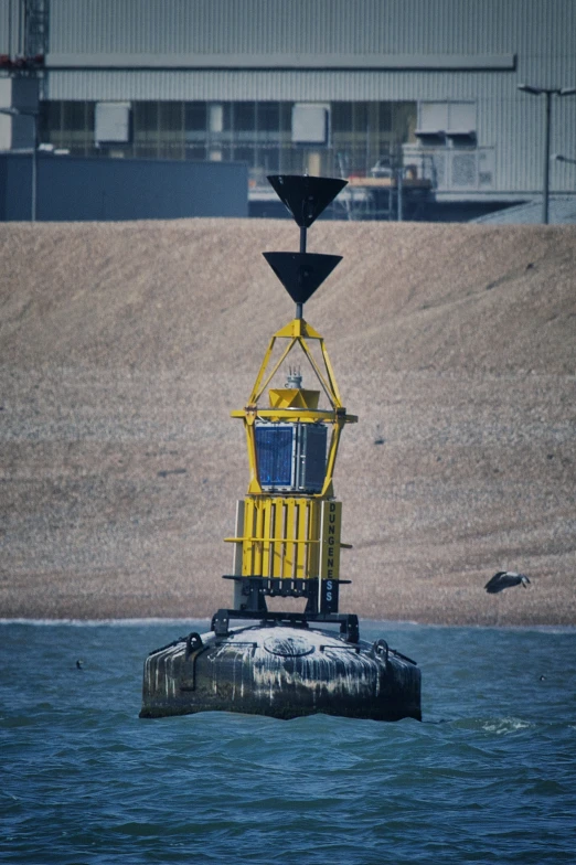 a yellow and blue buoy near water