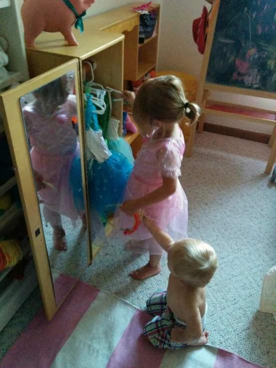 little girls play together in a room full of toys