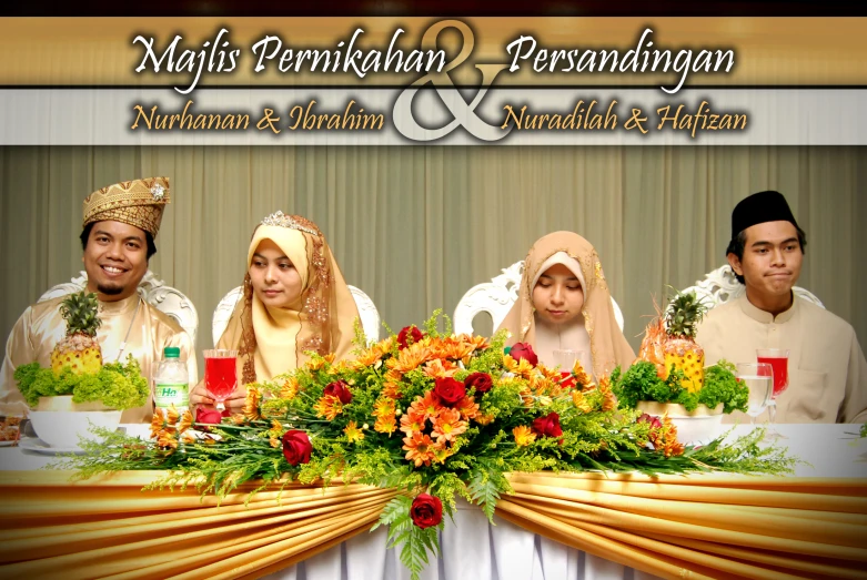 two bride and two grooms are sitting in front of a table