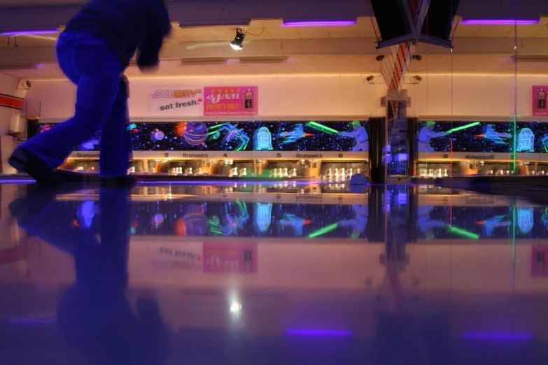 a bowling alley has bowling lights on as well as large windows