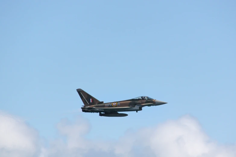 a fighter jet is in flight over some clouds